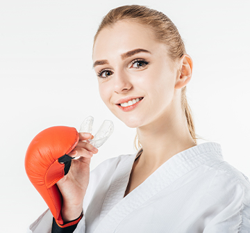 Teen girl holding athletic mouthguard