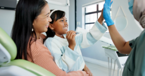 a child high-fiving their dentist